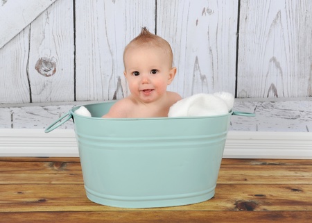 happy baby boy sitting in washtubの写真素材