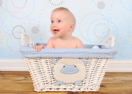 adorable baby boy in blue wicker basket の写真素材