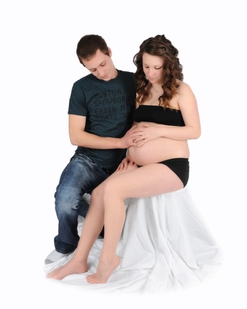 loving couple admiring womans bare pregnant belly. isolated on whiteの写真素材