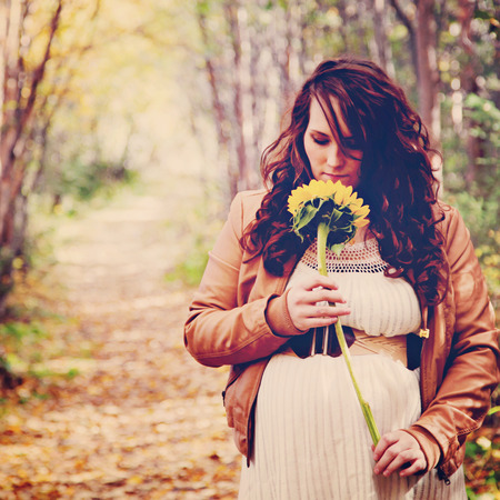 stunning pregnant woman on forest pathの写真素材