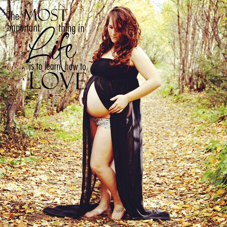 gorgeous of pregnant woman baring belly in the forest with typographyの写真素材