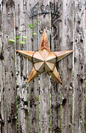 Rusty Star and Welcome Sign on a Weathered Wood Fenceの写真素材