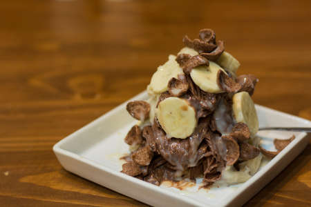 Banana and chocolate cereal and pour sweeted concerned milk on top.の写真素材