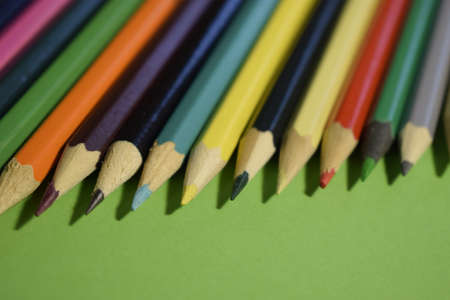 Closeup colorful pencil on green paper background