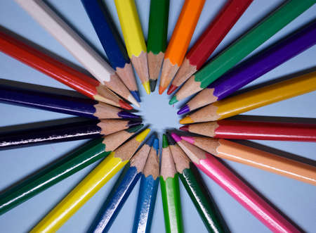Closeup colorful pencil on blue paper background. Macro of a group pencils in a circle. Business concept, teamwork, united groupの写真素材