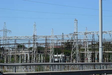 High voltage transmission towers, where many wires, have a clear sky background. View of electric...
