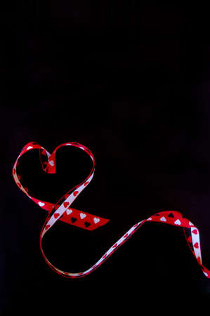 Ribbon forming heart on black background close upの写真素材