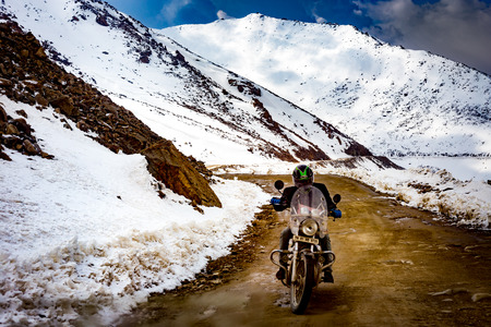 4 May 2016 - A man is riding a motorcycle to Nubra valley on the off-road pass in winter.のeditorial素材