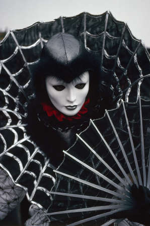 Venetian Carnival Figure in a colourful black and silver costume and mask Venice Italy Europeのeditorial素材