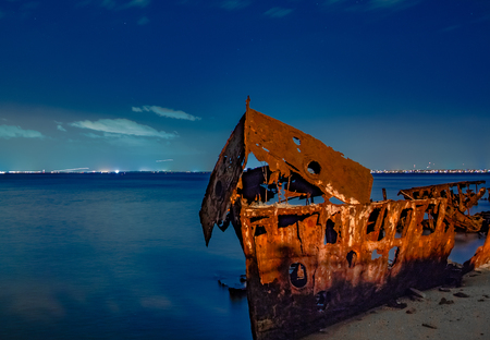 shipwrecked on a beach at nightの写真素材