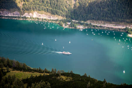 Mountain view from the top of a mountain on the lake Achen in Austria with touring boatsの写真素材