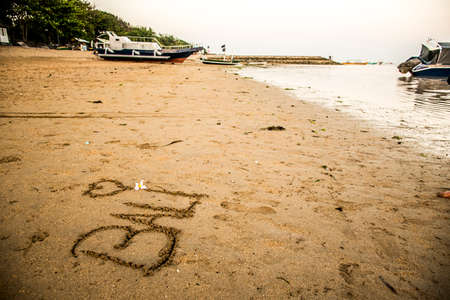 Bali Indonesia written in sand at Sanur Beach sunsetの写真素材