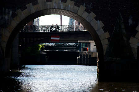 Hamburg City amorous couple sitting together at alster River under a bridgeの写真素材