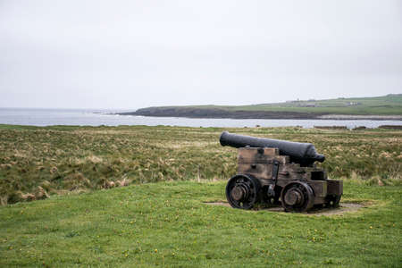 shooting cannon at Orkney coastline cliff landscapeの写真素材