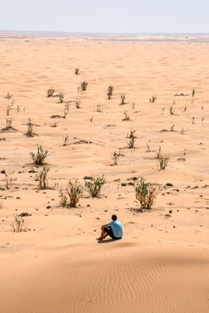Man tourist in desert rub al khali in Oman sitting in sand view landscape 3の写真素材