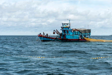 Fishing boat big fishermen with fish net on the blue ocean catch fish