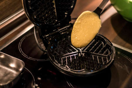 Homemade waffles are cooked in a waffle ironの写真素材