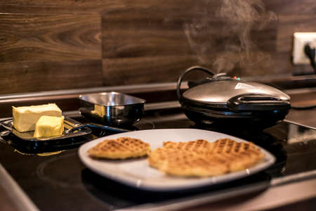 Homemade waffles are cooked in a waffle ironの写真素材