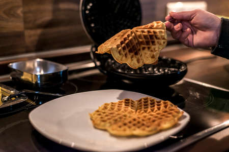 Homemade waffles are cooked in a waffle ironの写真素材