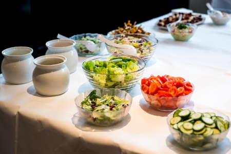 Variety of fresh salads bowls on a buffet table business dinner