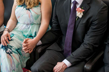 Young married couple holding hands during ceremony wedding dayの写真素材
