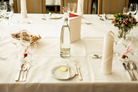 Table setup at marriage waiting for guests with dishes water flowersの写真素材