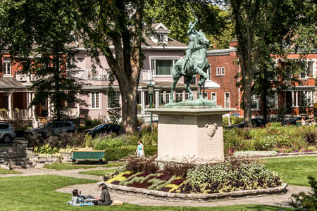 Quebec City 13.09.2017 Bronze statue Sancta Joanna D arc - Joan of Arc war memorial in a colorful garden on a sunny dayのeditorial素材