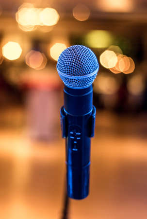 Close up of microphone in concert or conference hall with blurred lights at backgroundの写真素材