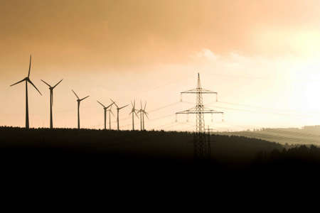 Black Silhouette of windturbines energy generator on amazing sunset at a wind farm in germanyの写真素材