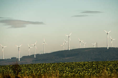 A panorama view over wind farm landscape in Germany with white generator turbines