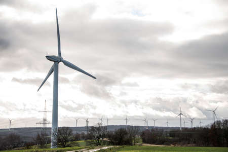 A panorama view over wind farm landscape in Germany with white generator turbines