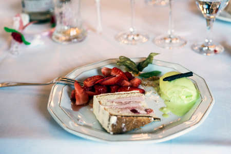 Strawberry fruit and cake and vanilla ice cream desert, served on a white plate, shallow focusの写真素材
