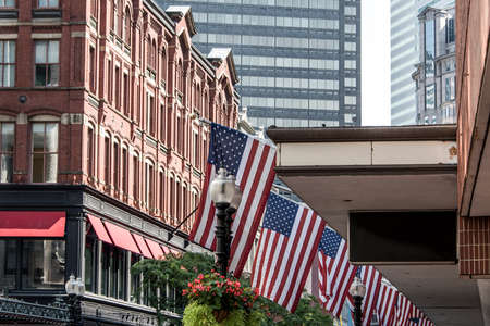Boston, MA USA - Shopping Mall Store front with american flags waving with skyscrapers in the...