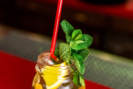 Homemade lemonade ice tea colorful icetea drink with fresh sweet fruits mint leaves in glass on the rocks with strawの写真素材
