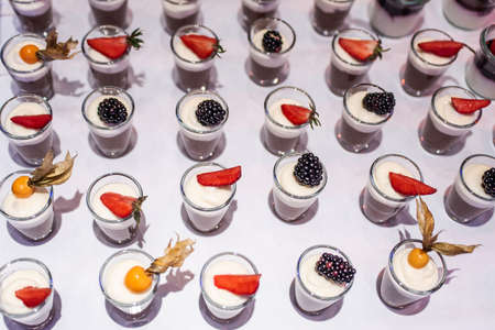 Closeup many dessert jar rowed up on buffet table with fresh fruits jelly and creamの写真素材