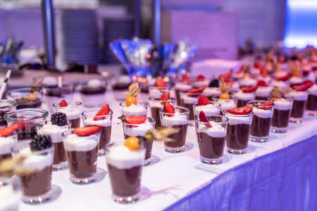 Closeup many dessert jar rowed up on buffet table with fresh fruits jelly and creamの写真素材