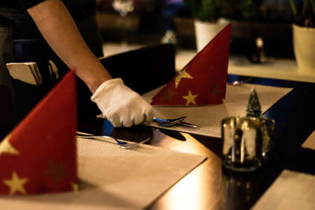Hand placing dishes on Christmas New Year Holiday Table Setting Dinner Decorations. Decorの写真素材
