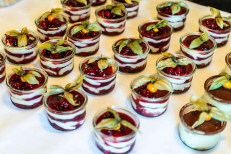 Closeup many dessert jar rowed up on buffet table with fresh fruits jelly and creamの写真素材