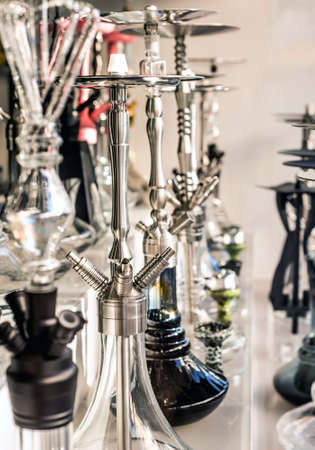A lot of glass colorful hookahs shisha in a window shop smoking smoke