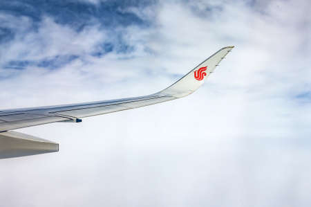 Air China wing of airplane in the sky red winglet blue sky cloudsのeditorial素材