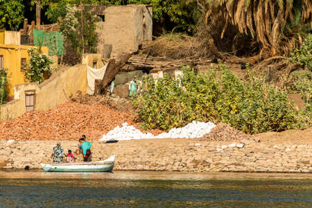 ASWAN, EGYPT 21.05.2018 Egyptian family working at the nile river bankのeditorial素材