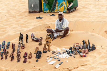 ASWAN EGYPT 20.05.18 Men souvenier seller with rolling store on the bay sand near Assuan in Egyptのeditorial素材