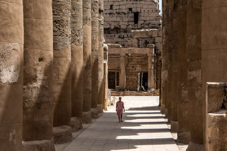 Girl young woman walking beside columns in Egypt Luxor Temple of Ramesses IIの写真素材