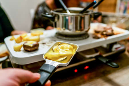 Swiss or Dutch raclette table filled with ingredients for a celebratory evening like Christmas or New Years Eveの写真素材