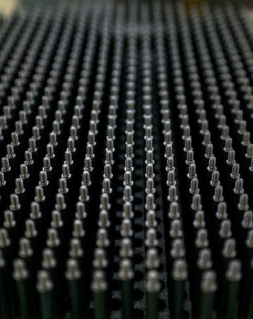 Close up shot of black screw thread bolts rowed up to a pattern background Artの写真素材