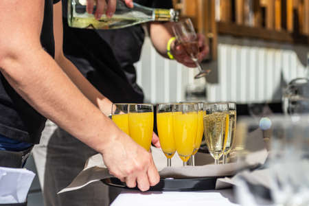 sparkling wine in glasses with orange juice in restaurant or wedding party dinner setting