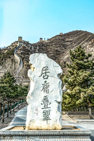 30.01.2019 Bejing China - ingraved Stone in front of a fragment of the Great Chinese Wall in the mountains near Bejingのeditorial素材