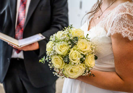 Wedding bouquet of flowers held by bride closeup. yellow roses flowerの写真素材