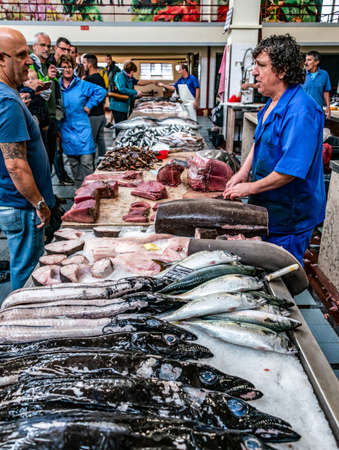 FUNCHAL, PORTUGAL 27.10.2018 Butcher prepares a tuna stack in Mercado dos Lavradores the famous fish and seafood marketのeditorial素材