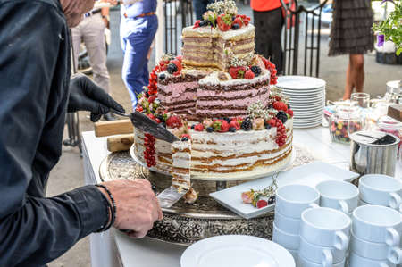 beautiful delicious Wedding cake in many tiers with fresh wild berries and fruits